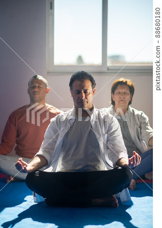 Aged people practicing meditation in gym 88680180