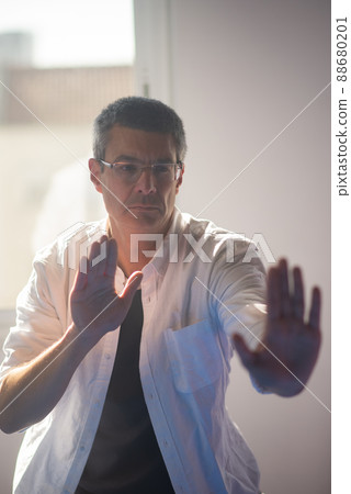 Mature man in eyeglasses performing Tai Chi exercise 88680201