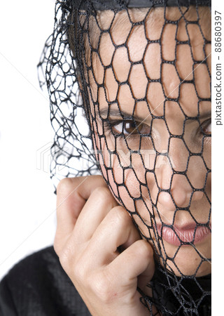 widowed woman dressed in black mourning her husband.  88680397