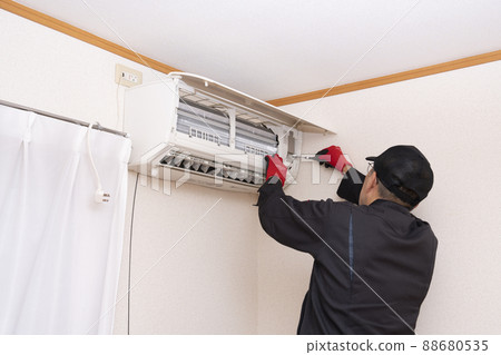 Worker installing an air conditioner 88680535