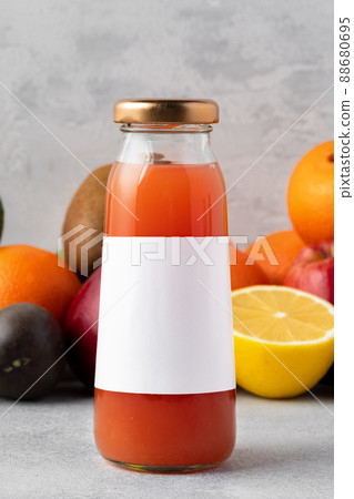 Various fruits and freshly squeezed fruits juice in bottle on gray background Various fruits and freshly squeezed fruits juice in bottle on gray background 88680695