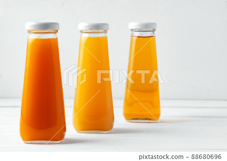 Glass bottles of different juices on white background Glass bottles of different juices on white background 88680696