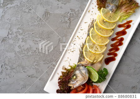 Fresh sea fish with lemon on plate Fresh sea fish with lemon on plate 88680831