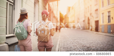 Two woman with backpacks walking in the old Tallinn, Estonia. 88680865