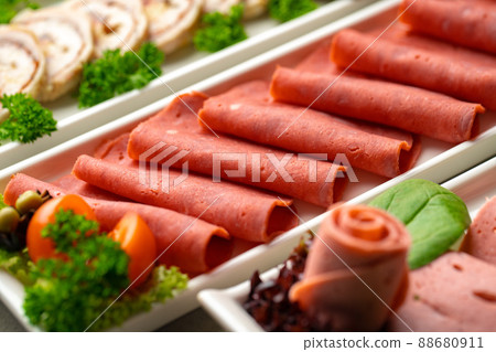 Platter of fresh meat cold cuts with vegetables. 88680911