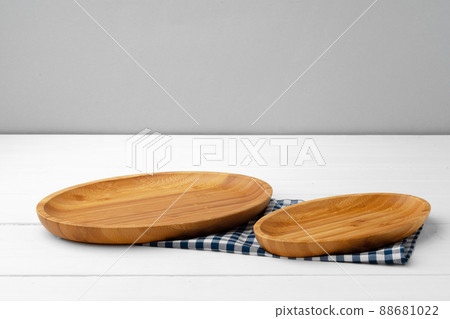 Wooden cutting board on cotton napkin on white wooden table Wooden cutting board on cotton napkin on white wooden table 88681022