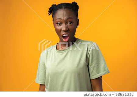 Frustrated beautiful African American female feels anxious and surprised, yellow studio Frustrated beautiful African American female feels anxious and surprised, yellow studio 88681333