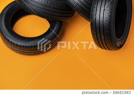 Car tires isolated on yellow background, close up 88681983