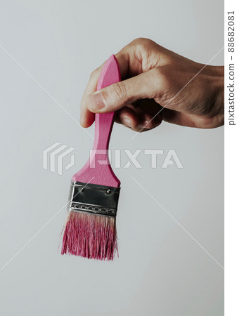 young man has a paintbrush with some pink paint 88682081