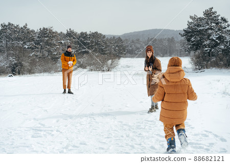 Young family having fun in winter snowy forest 88682121