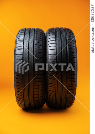 Car tires isolated on yellow background, close up Car tires isolated on yellow background, close up 88682587