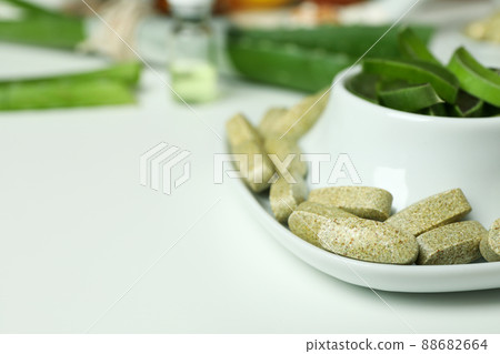 Concept of herb pills and cosmetics with aloe on white background 88682664