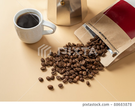 Cup of freshly brewed coffee and roasted beans on a beige background. Making tasty strong coffee. Cup of freshly brewed coffee and roasted beans on a beige background. Making tasty strong coffee. 88683878