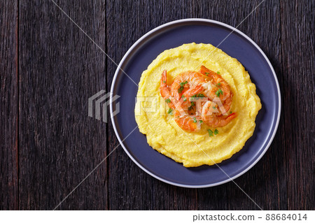 polenta with fried shrimps on plate, top view 88684014