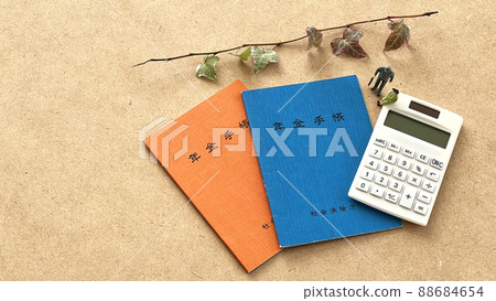 Two pension notebooks and miniature dolls for men and women_cork background_overview 88684654