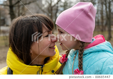A heartwarming portrait of a mother and her daughter face-to-face. A five-year-old Ukrainian girl touches a grown woman's nose with her nose. Family, relationships concept A heartwarming portrait of a mother and her daughter face-to-face. A five-year-old Ukrainian girl touches a grown woman's nose with her nose. Family, relationships concept 88685447