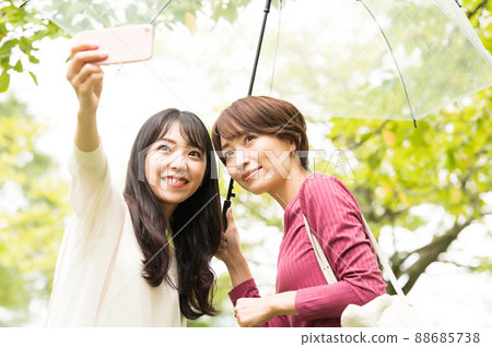 Two women taking a selfie on a rainy trip Two women taking a selfie on a rainy trip 88685738