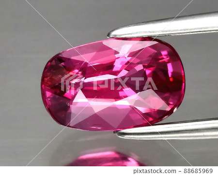 Natural gemstone red ruby in tongs on a gray background 88685969
