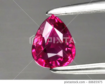 Natural gemstone red ruby in tongs on a gray background 88685975