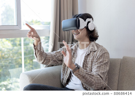 Man wearing virtual reality glasses is playing a 3D game with excitement, Man in glasses of virtual reality, VR, Future games, Gadgets, Technology, White background , VR game concept.  88686414