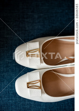 White shoes of the bride on a blue background. Wedding accessories 88686565