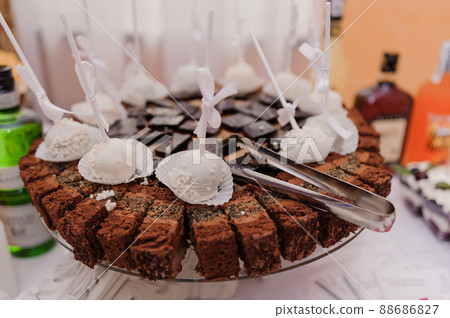Sweet cakes at a wedding banquet. Catering, sweet festive buffet. Candy bar Sweet cakes at a wedding banquet. Catering, sweet festive buffet. Candy bar 88686827