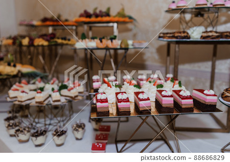 Sweet cakes at a wedding banquet. Catering, sweet festive buffet. Candy bar Sweet cakes at a wedding banquet. Catering, sweet festive buffet. Candy bar 88686829