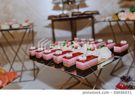 Sweet cakes at a wedding banquet. Catering, sweet festive buffet. Candy bar 88686831