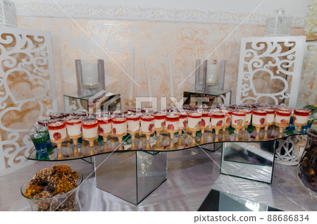 Sweet cakes at a wedding banquet. Catering, sweet festive buffet. Candy bar Sweet cakes at a wedding banquet. Catering, sweet festive buffet. Candy bar 88686834
