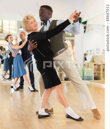 Man and senior woman dancing waltz in studio Man and senior woman dancing waltz in studio 88687012