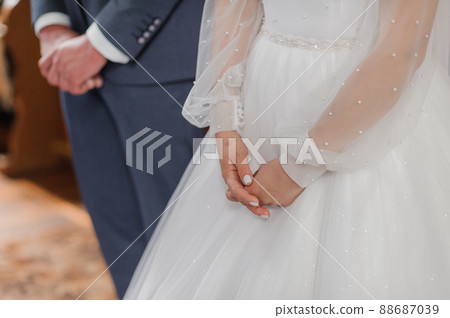 Wedding ceremony in the church. Hands of the bride and groom. wedding traditions Wedding ceremony in the church. Hands of the bride and groom. wedding traditions 88687039