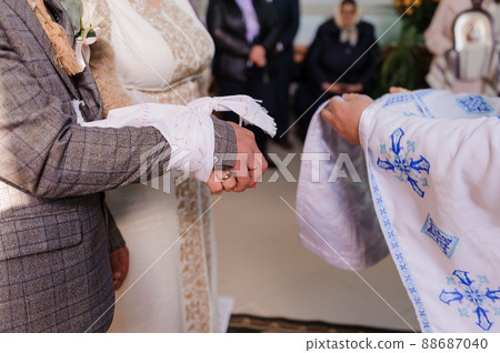 Wedding ceremony in the church. Hands of the bride and groom. wedding traditions Wedding ceremony in the church. Hands of the bride and groom. wedding traditions 88687040