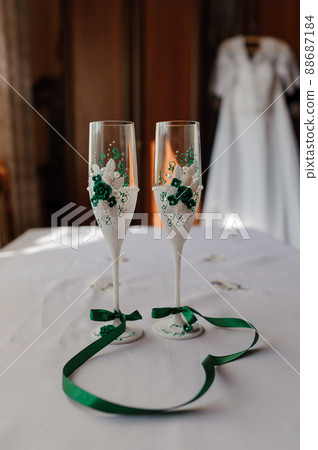 Wedding champagne glasses with green decor.... - Stock Photo [88687184]