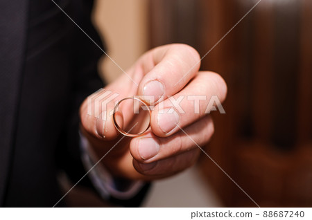 Wedding gold rings in the hands of the groom Wedding gold rings in the hands of the groom 88687240