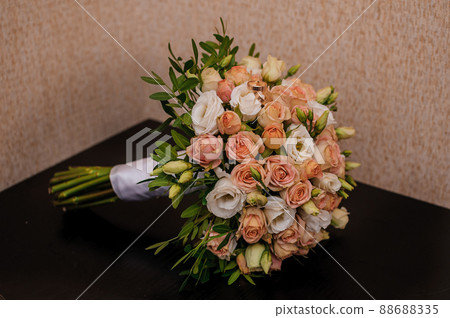 Bridal bouquet with orange roses. Gold wedding rings 88688335