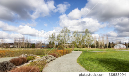 Scenic path in a park with green field and trees in a city. Scenic path in a park with green field and trees in a city. 88688994