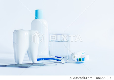 Oral hygiene products and model of tooth on white background. 88688997