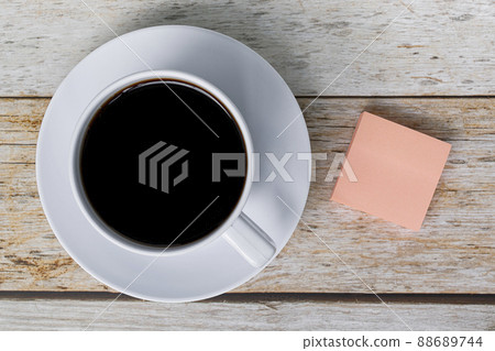 Note with white coffee cup on wooden desk. Flat lay. Copy space. 88689744