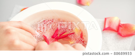 Female hands in a bowl of water with pink petals of rose flowers in spa Female hands in a bowl of water with pink petals of rose flowers in spa 88689933