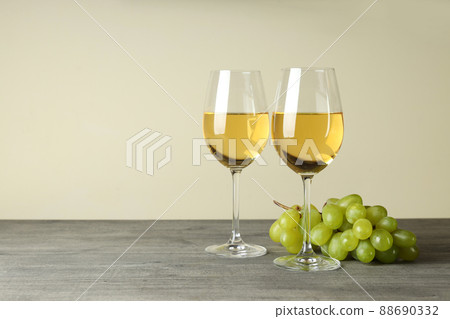 Glasses of white wine and grape on gray textured table 88690332
