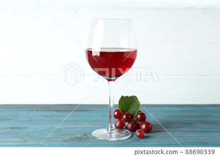 Glass of red wine and grape on wooden table Glass of red wine and grape on wooden table 88690339