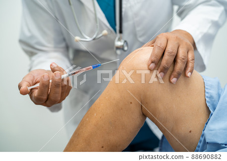 Asian doctor inject Hyaluronic acid platelet rich plasma into the knee of senior woman to walk without pain. 88690882