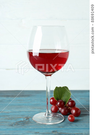 Glass of red wine and grape on wooden table Glass of red wine and grape on wooden table 88691409