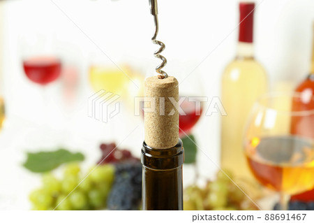 Corkscrew with cork, and wine bottle, close up Corkscrew with cork, and wine bottle, close up 88691467