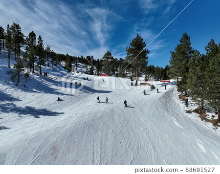 People skiing and snowboarding in mountain ski resort  88691527