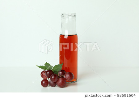 Bottle of vinegar and grape on white table 88691604