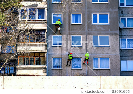Window cleaning urban alpinism brigade on building with windows and balconies on spring cleaning day Window cleaning urban alpinism brigade on building with windows and balconies on spring cleaning day 88691605