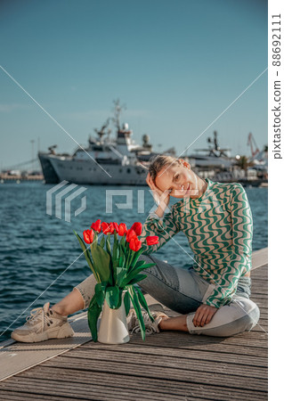 woman with a bouquet of red tulips in the jar 88692111