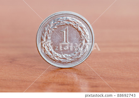 Polish 1 zloty coin on wooden table. Polish 1 zloty coin on wooden table. 88692743