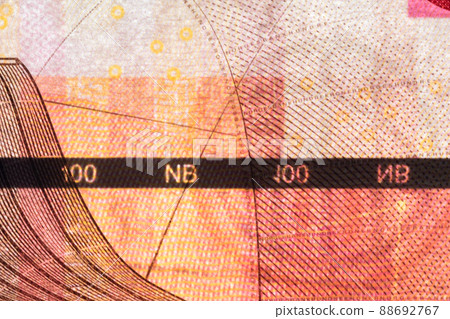 Plastic security strip inside 100 NOK banknote. Security strip on Norwegian krone banknote created to prevent counterfeiters. 88692767
